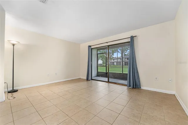 an empty room with kitchen view and a window