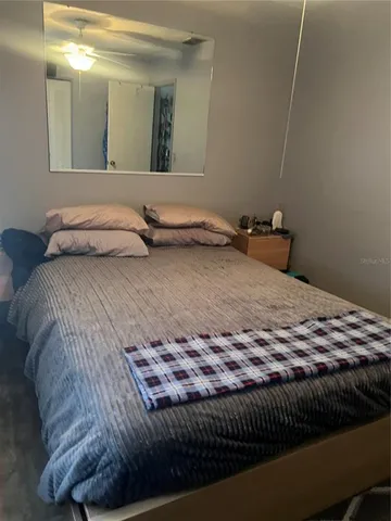 a bedroom with a bed and mirror