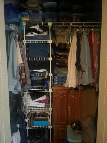 a view of walk in closet with clothes and shoes
