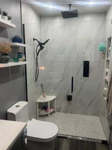 a bathroom with a granite countertop sink a toilet and a mirror