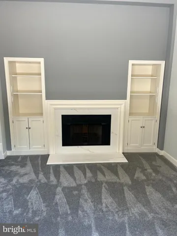 a view of an empty room with a fireplace and a window