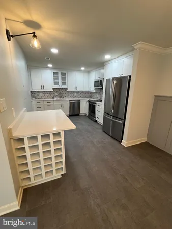 a view of kitchen with stainless steel appliances wooden floor and electronic appliances