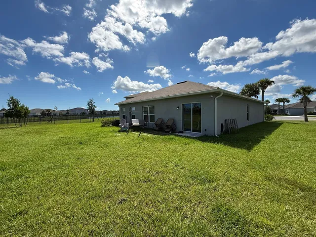 a view of a house with a yard and a patio