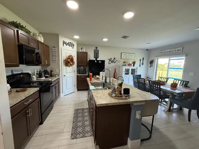 a kitchen with a dining table chairs and refrigerator
