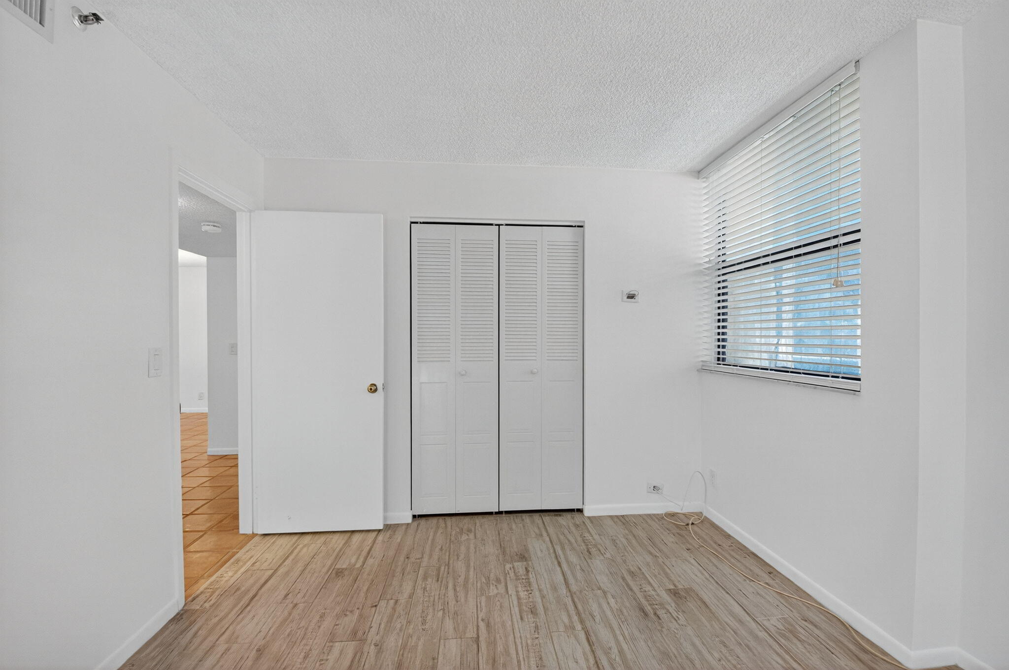 1850 Homewood Boulevard, Unit 214 Delray Beach, FL 33445 - Photo 17 of 38 a view of an empty room with wooden floor and a window