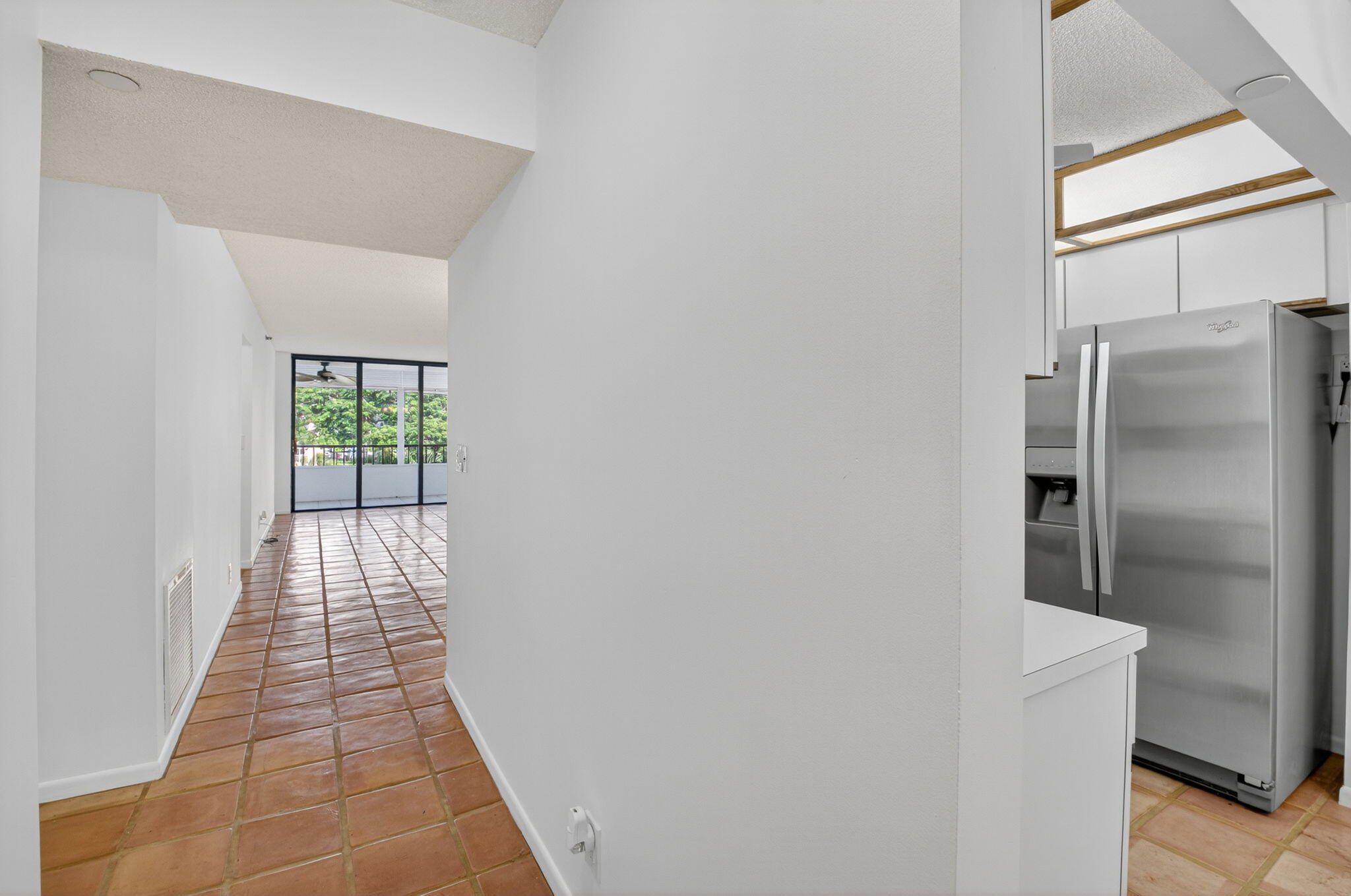1850 Homewood Boulevard, Unit 214 Delray Beach, FL 33445 - Photo 3 of 38 a view of a hallway with wooden floor and a refrigerator