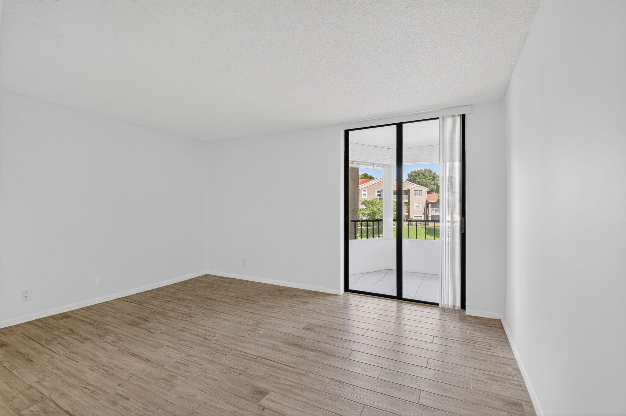 1850 Homewood Boulevard, Unit 214 Delray Beach, FL 33445 - Photo 10 of 38 a view of an empty room with wooden floor and a window