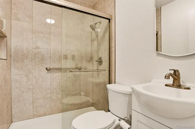 a bathroom with a sink a toilet and shower