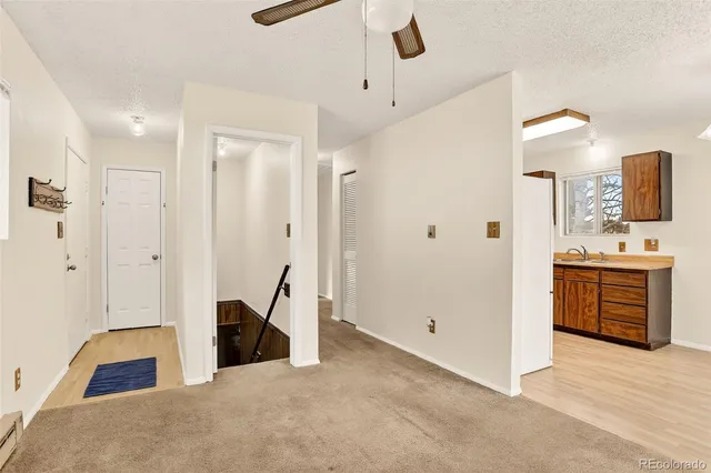 a view of a hallway with bathroom and a sink