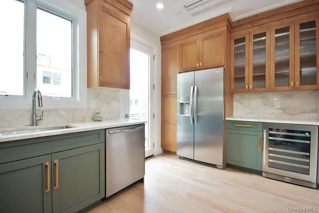 a kitchen with stainless steel appliances granite countertop a refrigerator and a sink