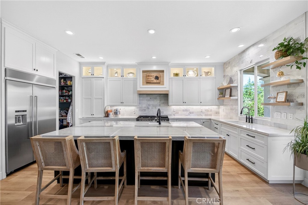 16375 Ory Circle Riverside, CA 92503 - Photo 12 of 51 a kitchen with stainless steel appliances granite countertop a dining table chairs refrigerator and sink