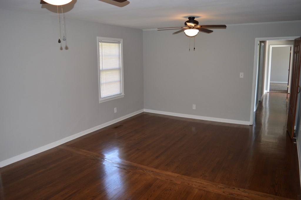 188 Kile Lake Road Cleveland, TN 37323 - Photo 6 of 23 an empty room with wooden floor chandelier fan and windows
