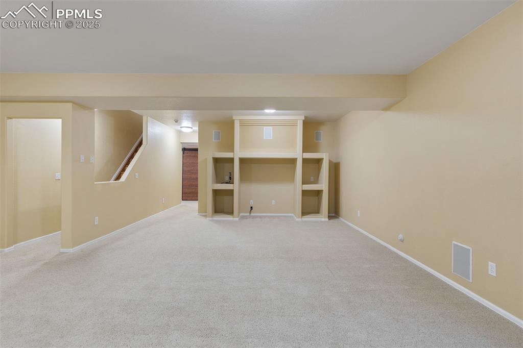 9015 Oakmont Road Peyton, CO 80831 - Photo 27 of 44 an empty room with a fireplace and cabinet