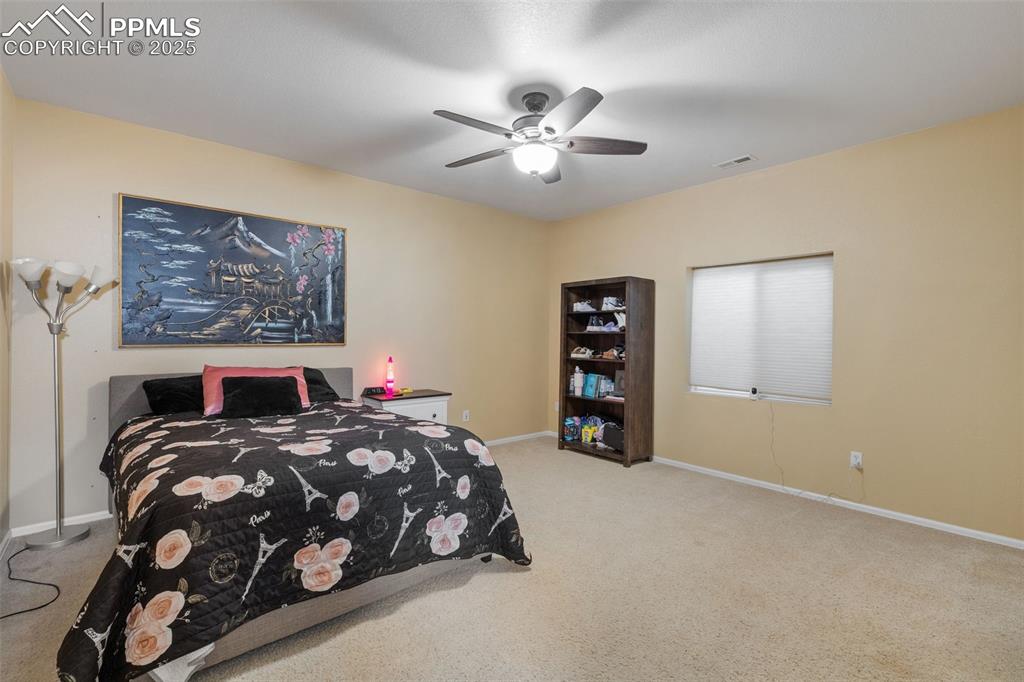 9015 Oakmont Road Peyton, CO 80831 - Photo 29 of 44 a bedroom with a bed and a chandelier