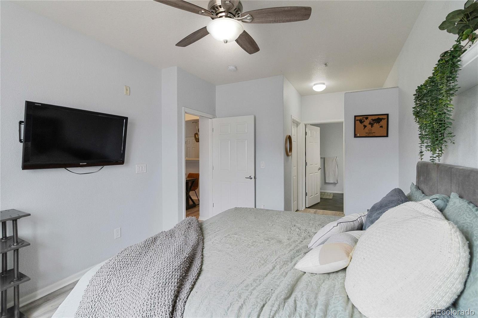5255 Memphis Street, Unit 702 Denver, CO 80239 - Photo 16 of 30 a bedroom with a bed and a flat screen tv