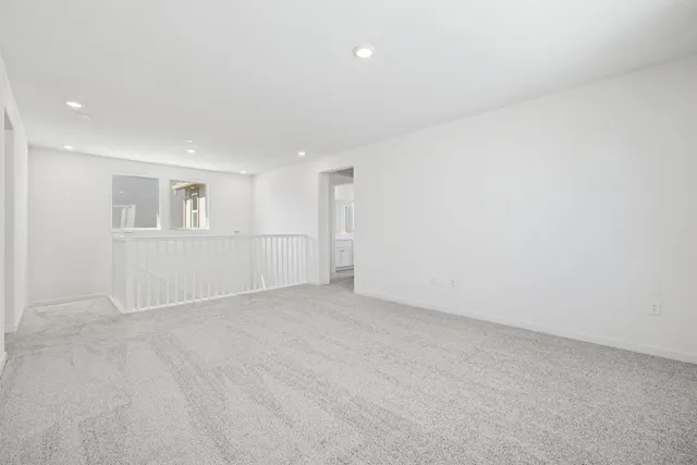 an empty room with white walls and windows