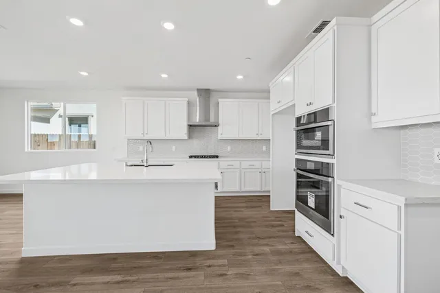 a kitchen with stainless steel appliances a stove top oven a sink and a refrigerator