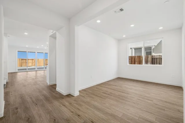 a view of a kitchen with wooden floor and a window