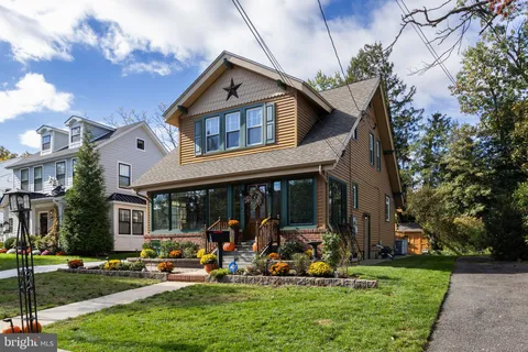 a front view of a house with garden and sitting area