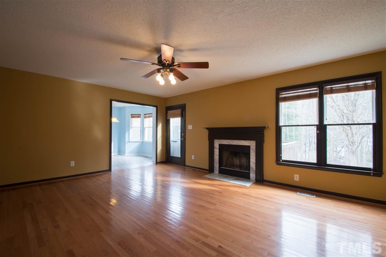 500 Jordan Ridge Lane Raleigh, NC 27603 - Photo 4 of 12 an empty room with windows fireplace and wooden floor