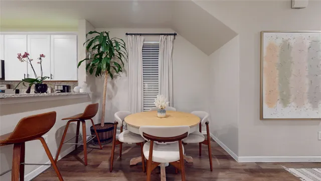 a kitchen with stainless steel appliances a dining table chairs stove and cabinets