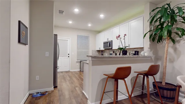 a kitchen with stainless steel appliances granite countertop a stove a sink and white cabinets