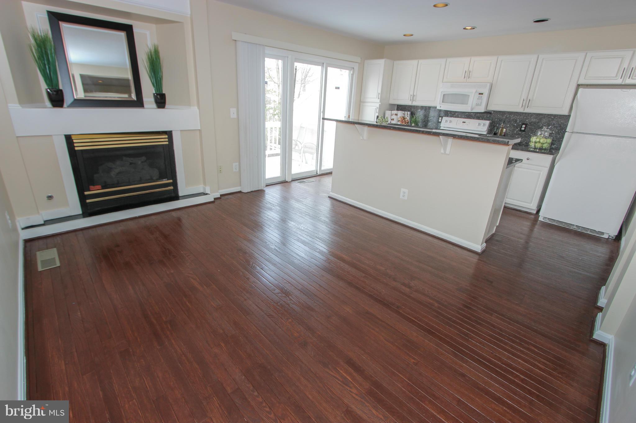 1706 Random Stone Court Reston, VA 20190 - Photo 25 of 30 a view of a kitchen with wooden floor and a fireplace