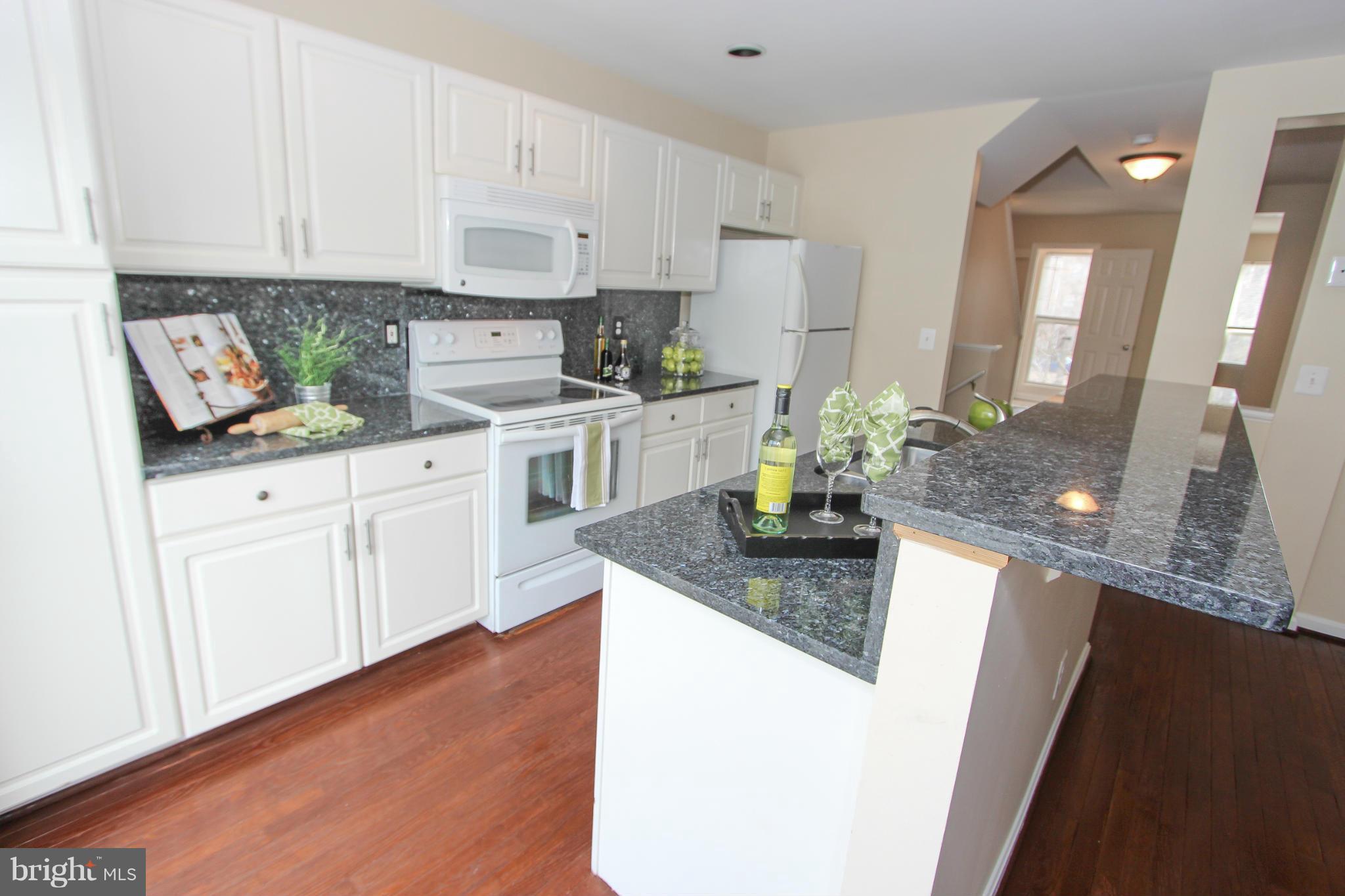 1706 Random Stone Court Reston, VA 20190 - Photo 29 of 30 a kitchen with white cabinets and white appliances