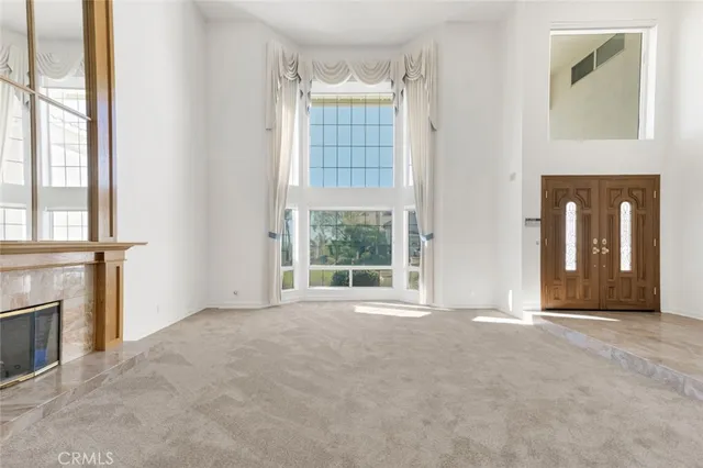 an empty room with windows and fireplace