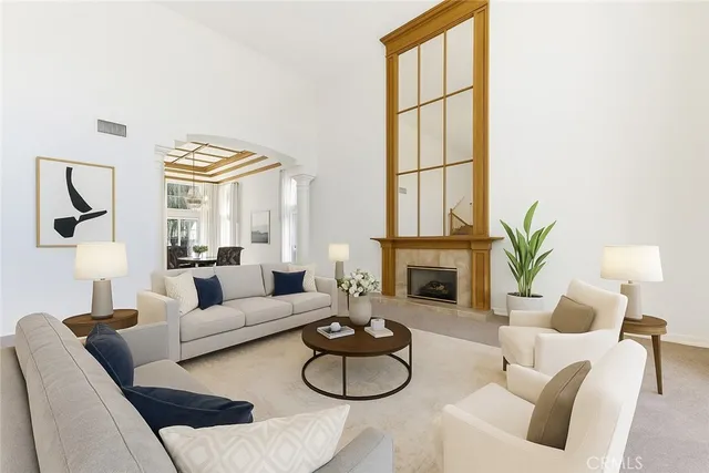 a living room with furniture a fireplace and a large window