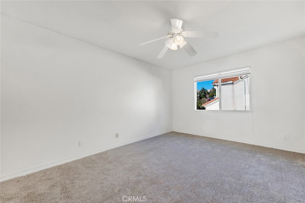 19641 Falcon Ridge Way Porter Ranch, CA 91326 - Photo 39 of 51 an empty room with a chandelier fan and windows