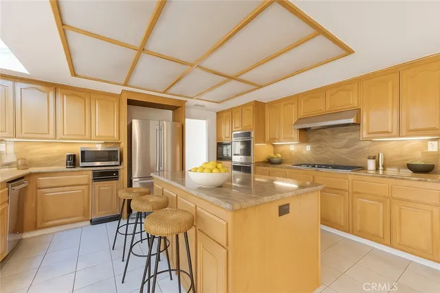 a kitchen with kitchen island granite countertop a sink appliances cabinets and furniture