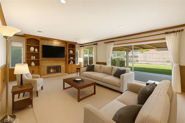 a living room with furniture a flat screen tv and a floor to ceiling window