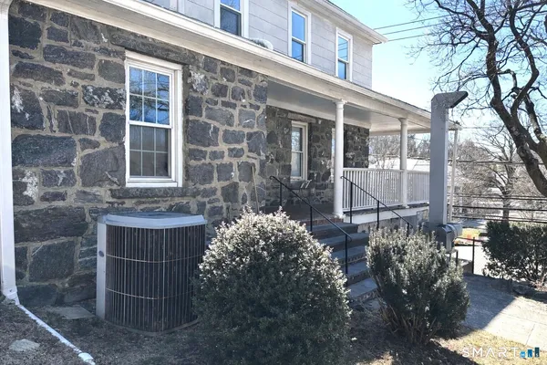 a view of a brick house with a yard and potted plants