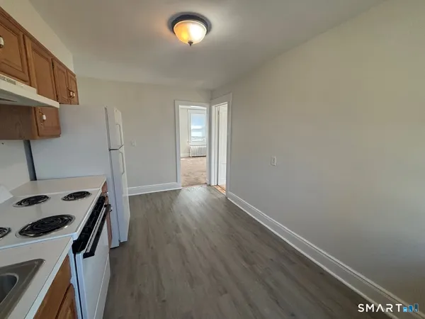 a view of a room with wooden floor and cabinets