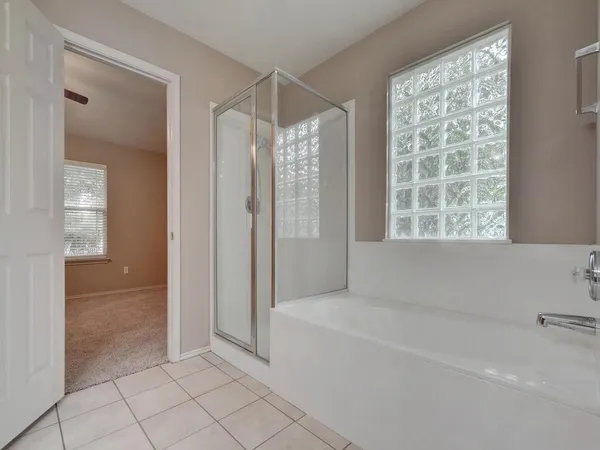 a spacious bathroom with a bathtub and shower