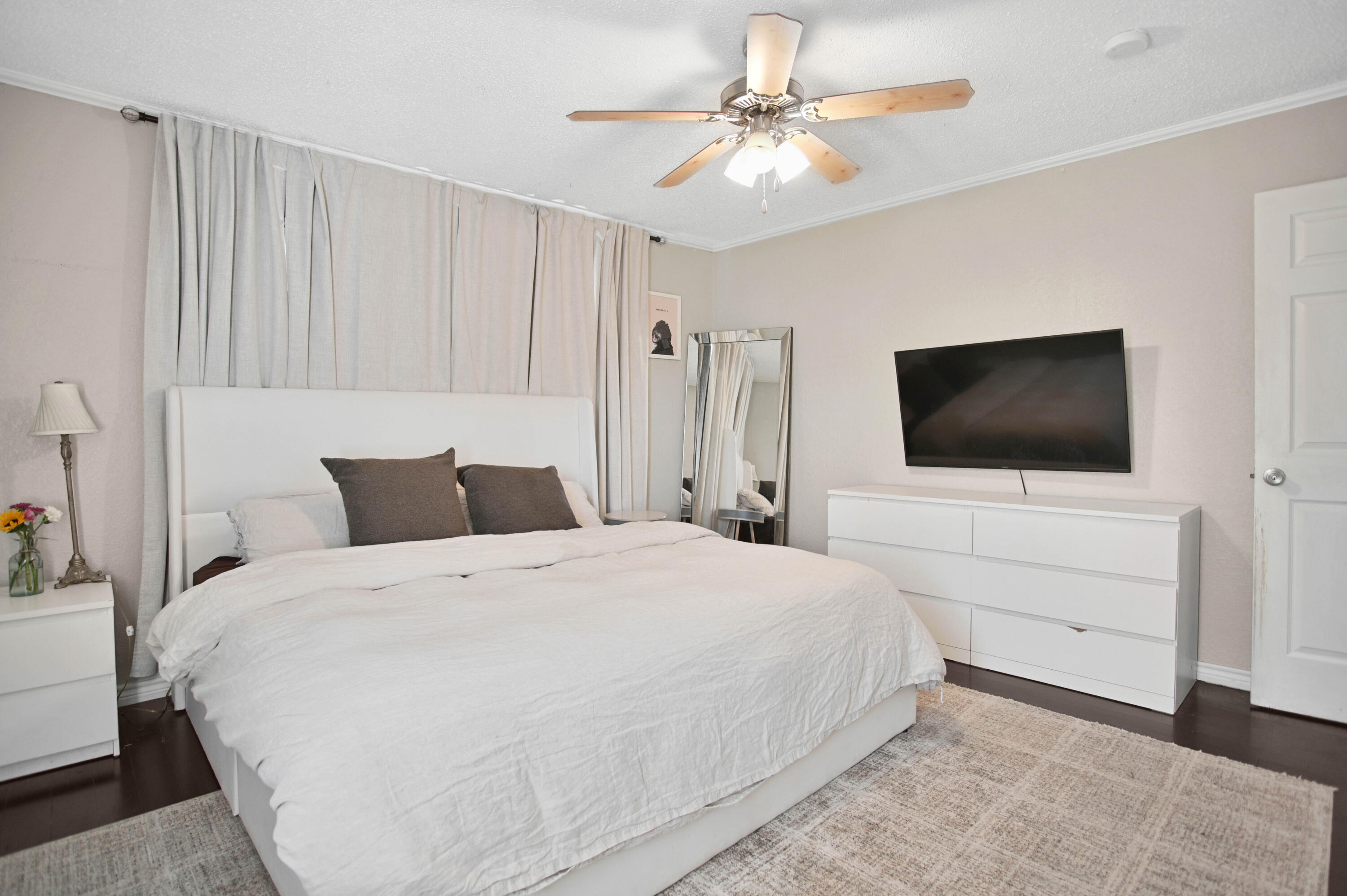 4102 32nd Street Lubbock, TX 79410 - Photo 23 of 40 a bedroom with a bed tv and wooden floor