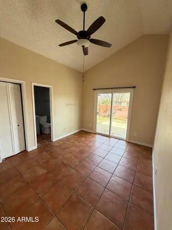 a view of a livingroom with a chandelier fan and windows