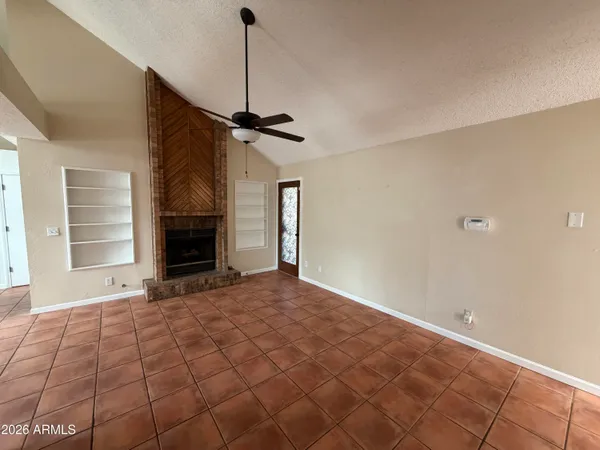 a view of an empty room with a fireplace and a window