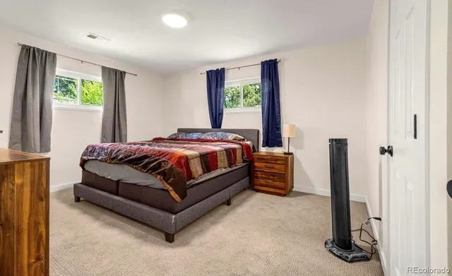 a bedroom with a bed and a dresser next to a window