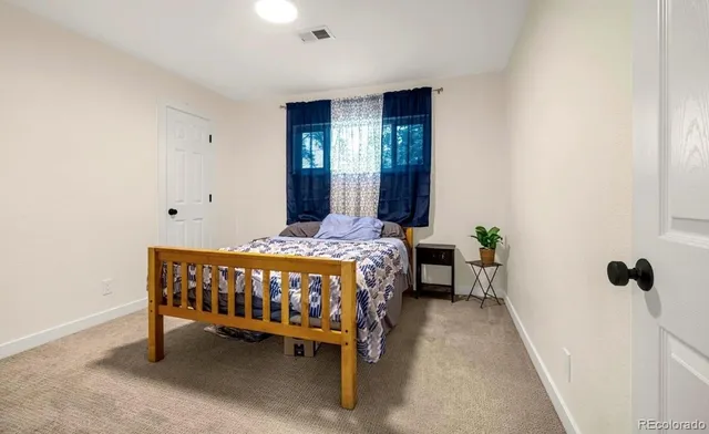 a bed sitting in a bedroom next to a window