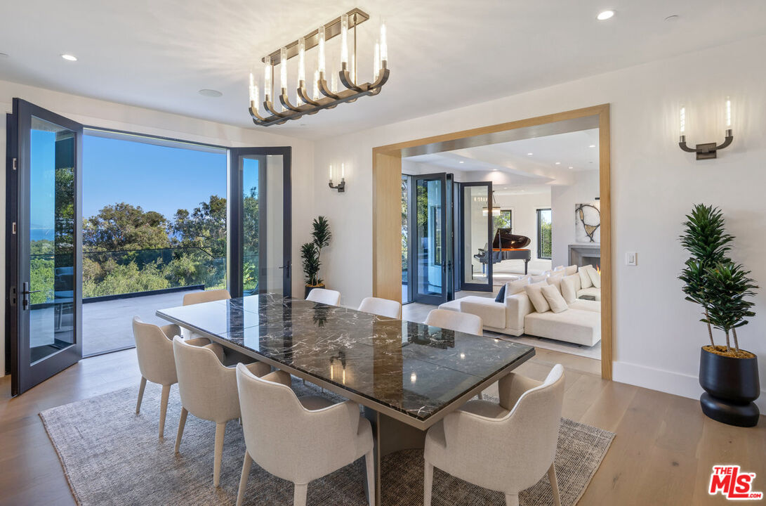 7052 Dume Drive Malibu, CA 90265 - Photo 17 of 52 a dining room with furniture a livingroom and chandelier