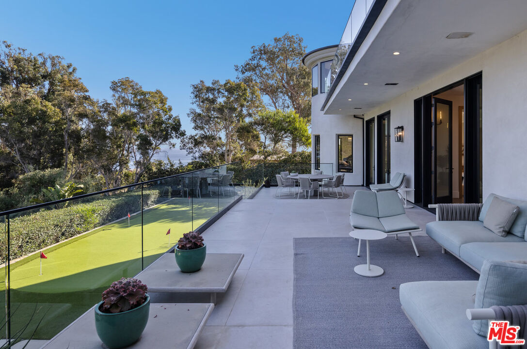 7052 Dume Drive Malibu, CA 90265 - Photo 20 of 52 a living room with furniture and a swimming pool