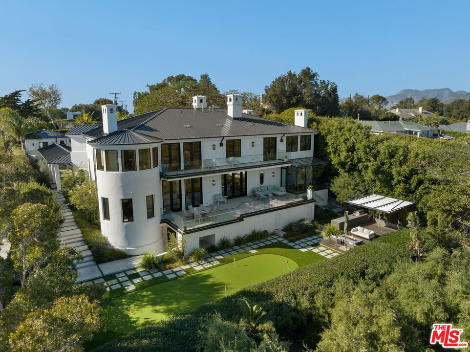 7052 Dume Drive Malibu, CA 90265 - Photo 2 of 52 a aerial view of a house with a yard table and chairs