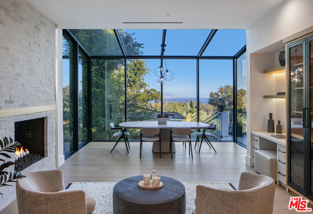 7052 Dume Drive Malibu, CA 90265 - Photo 31 of 52 a dining room with furniture and a floor to ceiling window