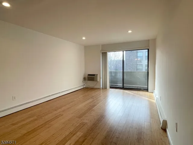 an empty room with wooden floor and sliding door