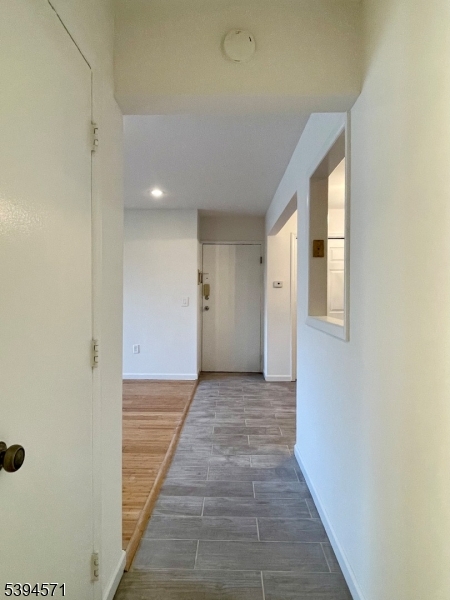 6 River Road, Unit K Nutley, NJ 07110 - Photo 14 of 21 a view of a hallway to an empty room with wooden floor and a window