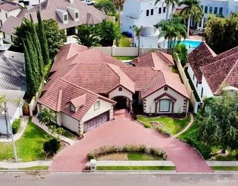 an aerial view of a house with a garden and lake view