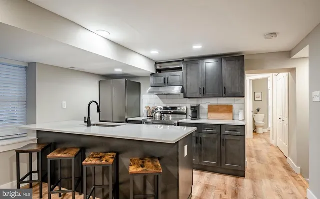 a kitchen with stainless steel appliances granite countertop a sink a stove and a refrigerator