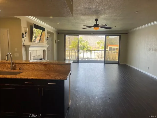 a view of a kitchen with granite countertop a stove a sink a window and a dining table